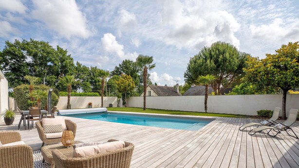 A wooden deck with a pool, wicker furniture, and trees. - Ground floor room with terrace (SUCE-SUR-ERDRE)