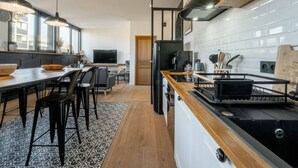 Una cocina moderna con estufa, refrigerador y comedor.