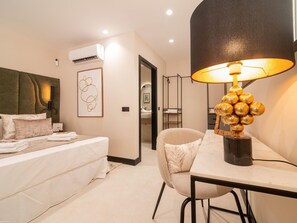 A hotel room with a bed, a desk, a chair, an air conditioning unit, and a wall-mounted lamp. - Modern loft for 4 guests in Valencia (València)