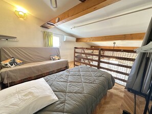 Une pièce confortable avec un lit, un canapé, une fenêtre donnant sur un beau paysage et un plafond en bois.