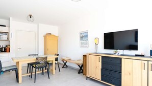 Una cocina moderna con comedor, televisor y un mueble.