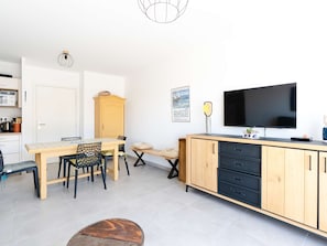 A modern kitchen with a dining area, a TV, and a cabinet. - Modern apartment, balcony and parking - 4 guests (Narbonne-Narbonne Plage-Narbonne Plage)