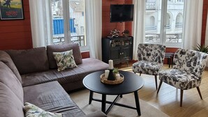 Un salon avec un canapé, un fauteuil et une table ronde décorée de bougies.