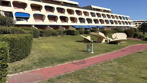 A hotel with a modern architectural design, featuring multiple balconies and a well-maintained lawn area.