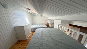 Quarto com cama grande, cômoda e janela.
