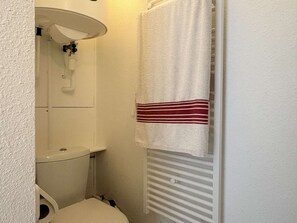A small bathroom with a toilet, a white sink, and a towel hanging on the wall. - T4 Duplex, parking, sea view - 6 guests (Banyuls-sur-Mer)