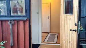 A wooden door with a metal handle, a white door with a black handle, and a window with a metal grate. - 3 Person Holiday Home in Bengtsfors (Bengtsfors)