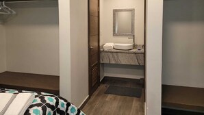Un bagno piccolo e funzionale con lavandino, specchio e portasciugamani.