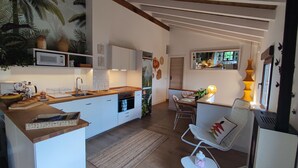 Una cocina moderna con armarios blancos, encimera de madera y horno empotrado.