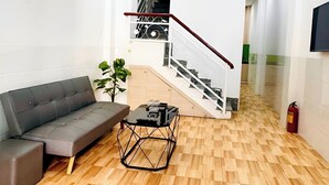 Una sala de estar moderna con sofá, mesa de centro y ventilador de techo.