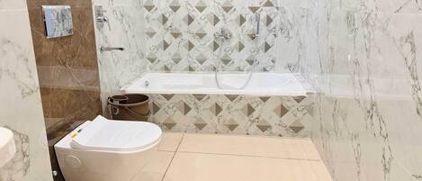 A modern bathroom with a toilet, sink, and bathtub.