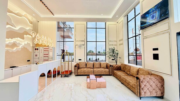 A modern interior with a plush brown sofa, a marble floor, and a wall with a unique light design.