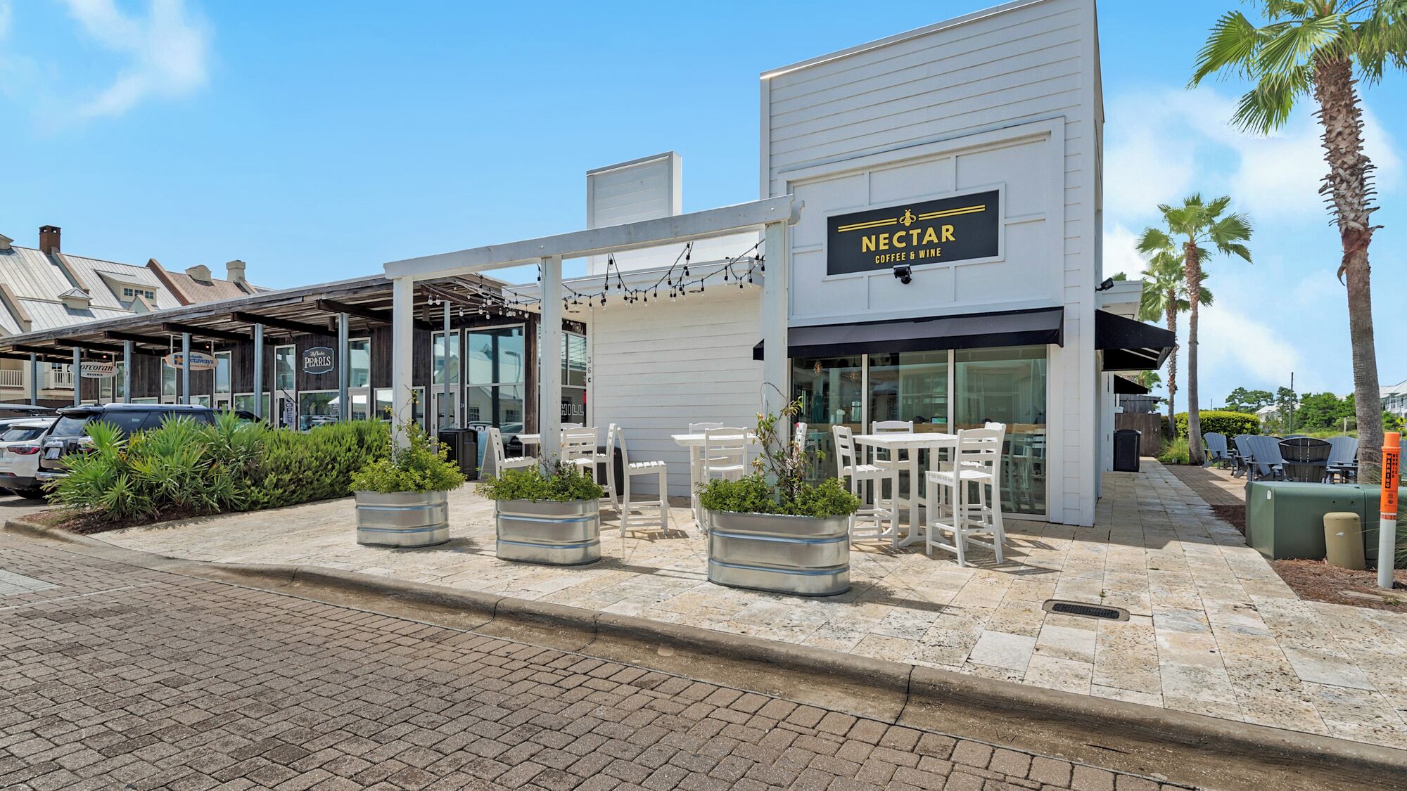 Una tienda de Nectar Coffee & Wine con terraza y macetas.