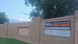 A sign for Pilgrims Corner Guest House advertising 24/7 availability, high-speed Wi-Fi, spacious rooms, free parking, and 24/7 security. - Brilliant 5-bedroom house with spacious rooms and great security in Westonaria (Westonaria)
