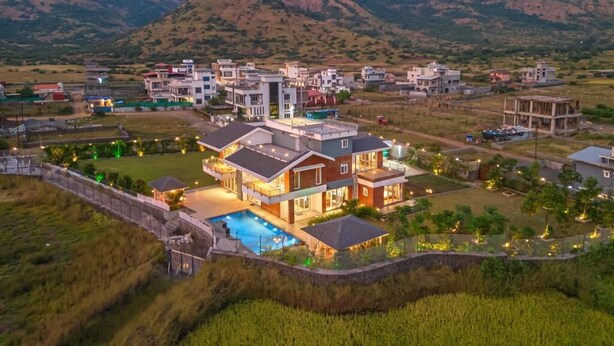 Un quartier résidentiel avec des maisons modernes, une piscine et un paysage vallonné en arrière-plan.