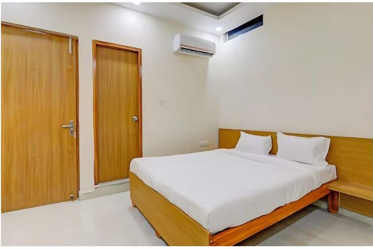 Un dormitorio con cama, armario de madera y equipo de aire acondicionado.