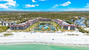 Et resort med flere bygninger, en fælles pool og en strand.