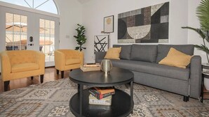 A living room with a grey sofa, yellow armchair, and a round coffee table.