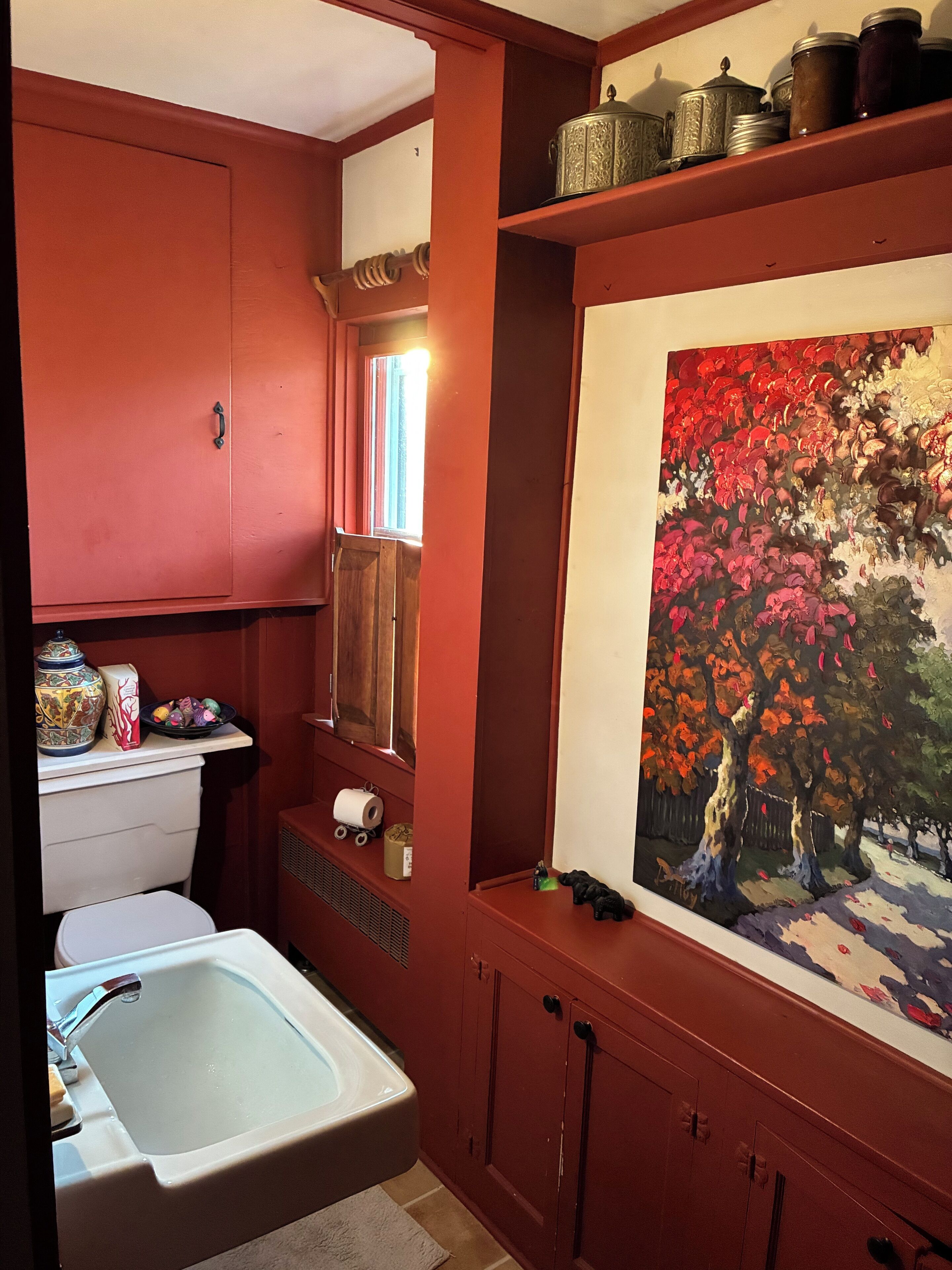 Une salle de bain avec une baignoire, des toilettes, un lavabo, un miroir et un tableau accroché au mur.