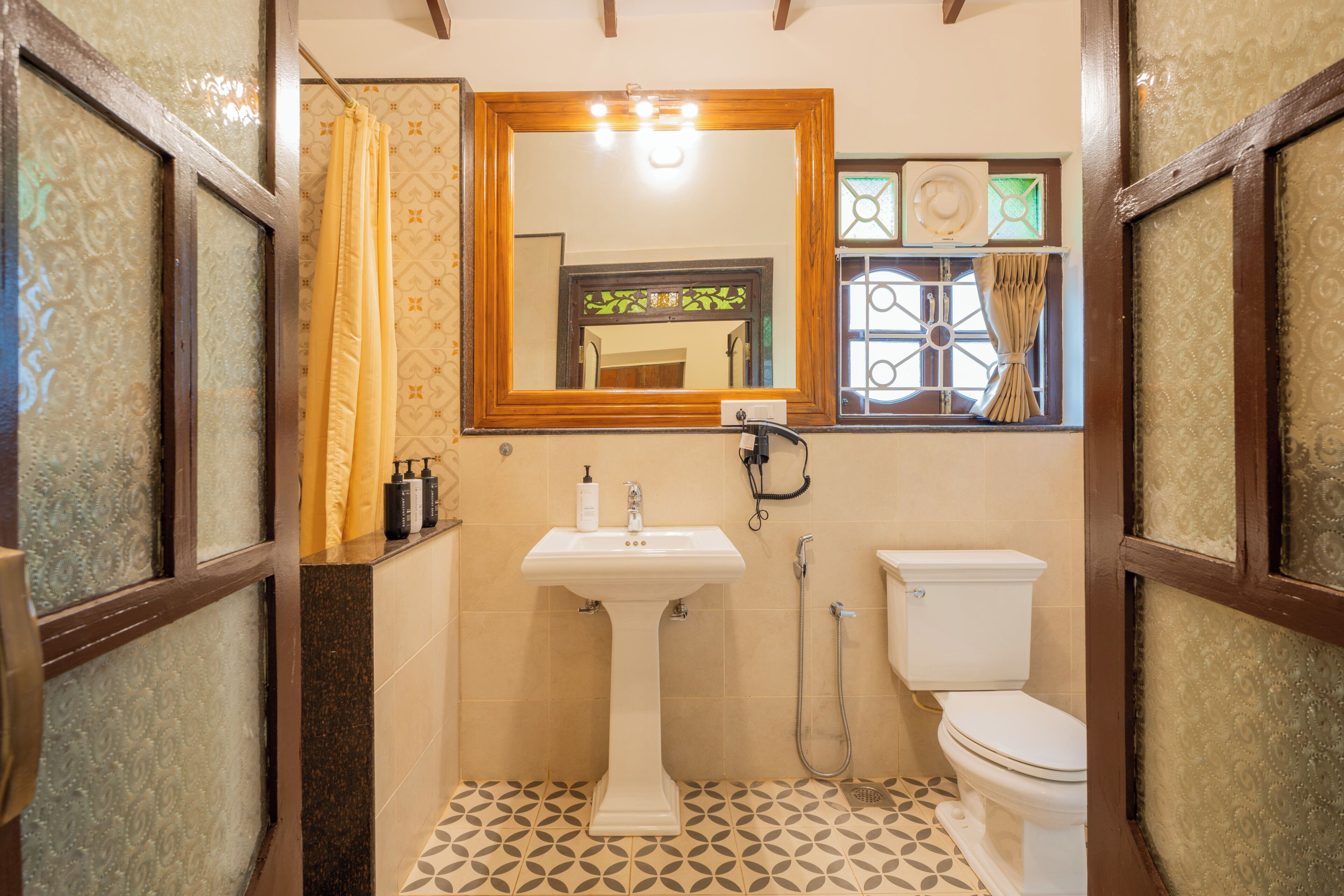 A bathroom with a pedestal sink, a toilet, and a shower area.