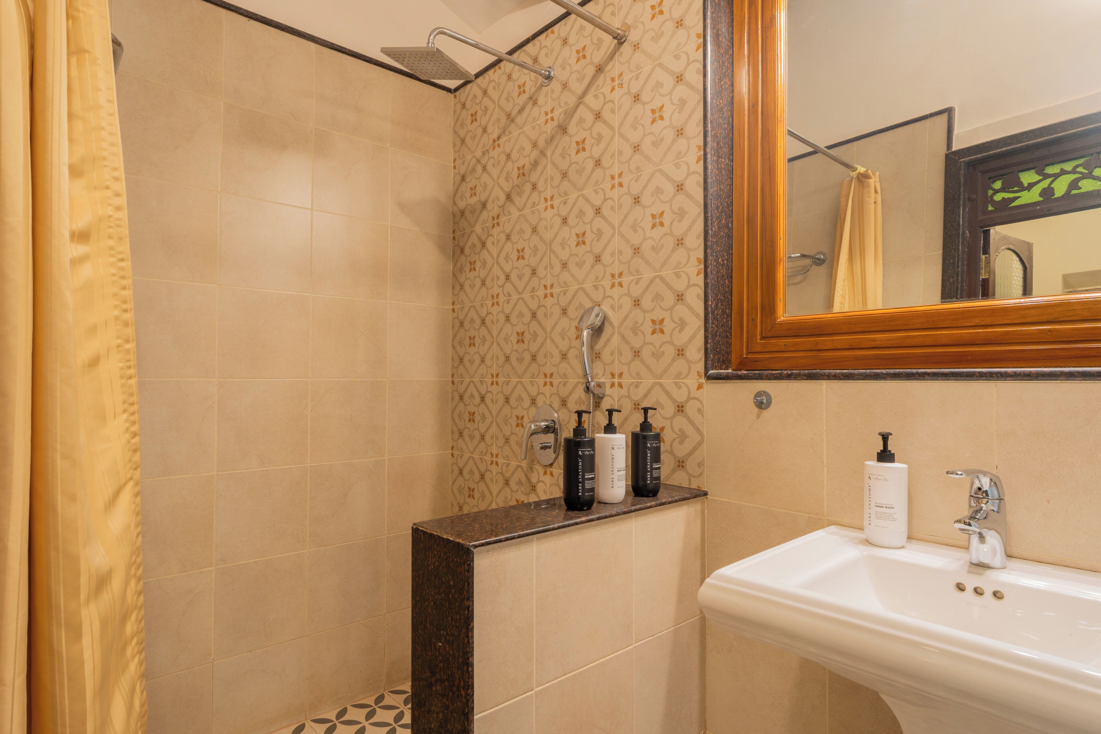 A bathroom with a shower, a sink, and toiletries.
