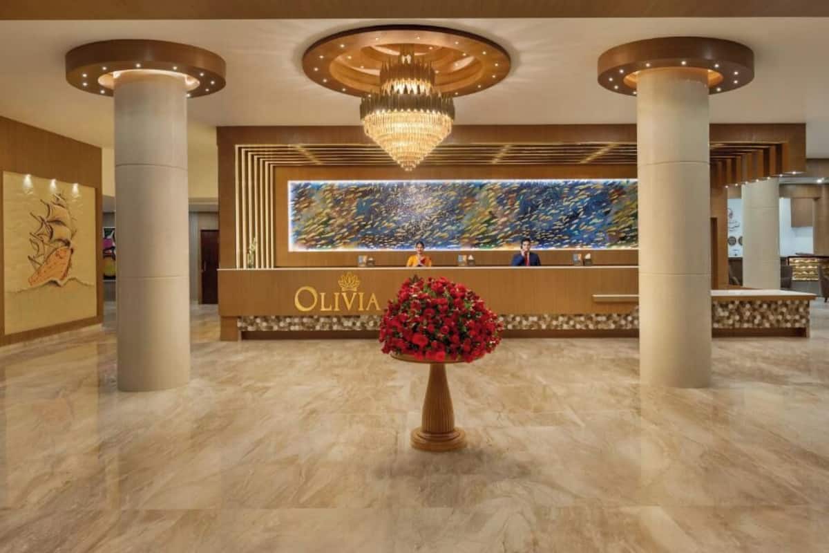 A reception area with a chandelier, a reception desk, and a large abstract painting.