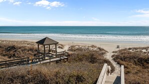 A beach with a wooden structure, a wooden walkway, and a clear view of the ocean. - Dune Daze-Ocean Front Condo in Dunescape Villas (Atlantic Beach)