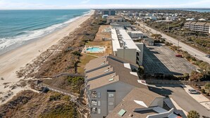 A coastal hotel with a beach view, a swimming pool, and a parking lot. - Dune Daze-Ocean Front Condo in Dunescape Villas (Atlantic Beach)