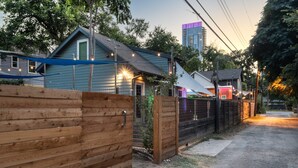 A residential area with houses, a wooden fence, and a dirt road. - East Austin Bungalow w BBQ Firepit Fun Yard (Austin)