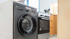 A modern kitchen with a built-in washing machine and oven. - Free Housekeeping Visits During Your Stay - Stayshort - Relaxing 1 Bedroom in JVC That Sleeps 2 (Dubai)