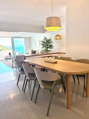 Un comedor moderno con una mesa de madera, sillas y una lámpara colgante.
