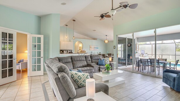 A spacious living area with a grey sofa, a white coffee table, and a ceiling fan. - Pool Paradise! Cape Coral Retreat w/ Beach Gear (Cape Coral)