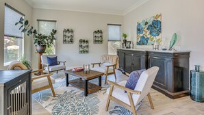 A spacious living room with a large window, a fireplace, and a dining area. - LA Costa Valley Newly Remodeled Gem (Carlsbad)
