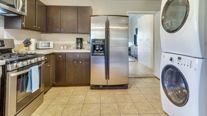 Una cocina equipada con un refrigerador de acero inoxidable, horno, microondas y un horno doble.