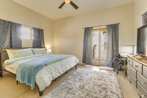 A bedroom with a bed, a desk, a chair, a television, and a ceiling fan. - 2 Mi to Old Town Abq! Cozy Desert Retreat (Albuquerque)