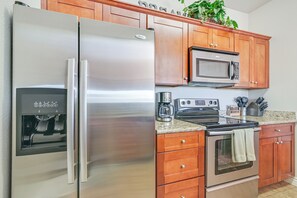 A kitchen with stainless steel appliances, wooden cabinets, and a granite countertop. - Hike & Golf in Fountain Hills! Resort-style Condo (Fountain Hills)