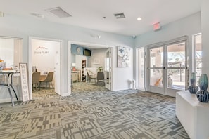A hotel lobby with patterned carpet, a reception desk, and a view through the glass doors. - Hike & Golf in Fountain Hills! Resort-style Condo (Fountain Hills)