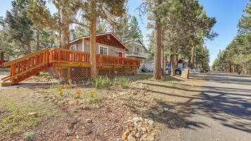 A two-story house with a wooden deck and a small porch.
