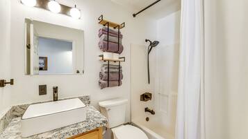 A bathroom with a sink, toilet, and bathtub.