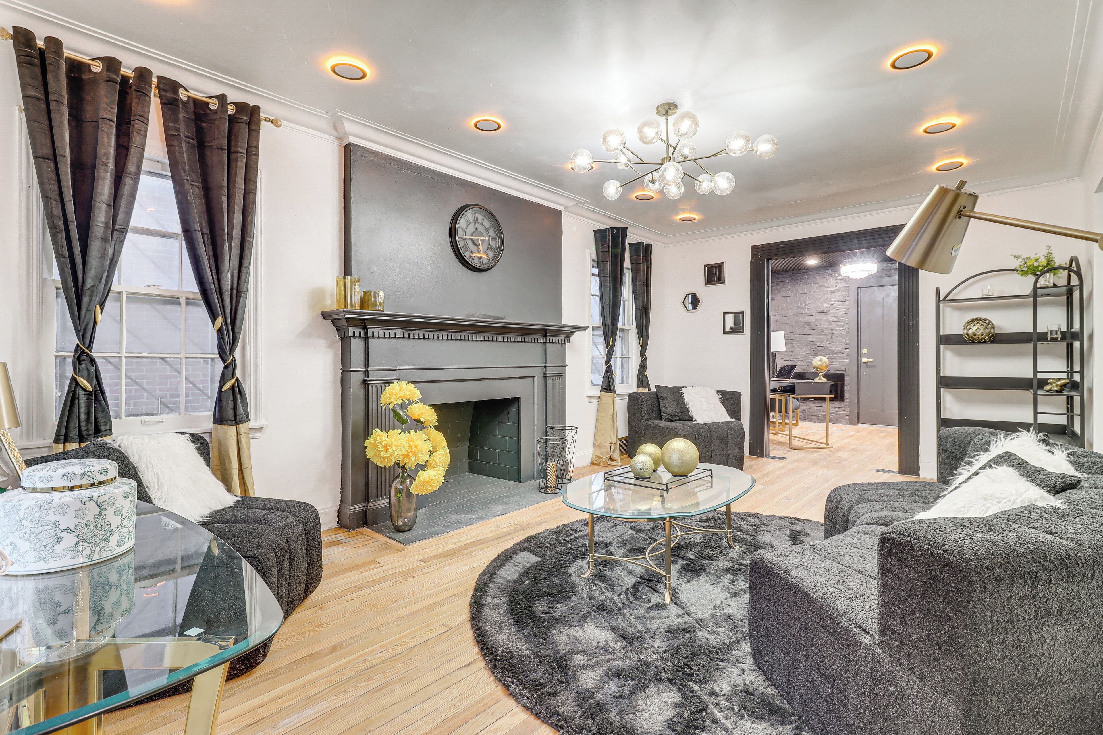 A modern living room with a fireplace, a glass coffee table, and a sofa.