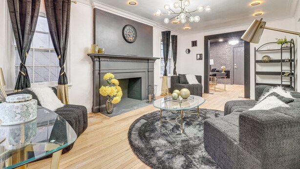 Een moderne woonkamer met een open haard, een glazen salontafel en een bank.