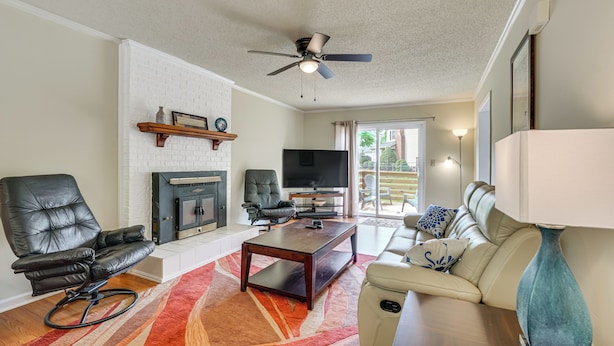 A living room with a fireplace, a ceiling fan, a TV, a sofa, and a coffee table. - Quiet Family Home w/ Yard! 9 Mi to Dtwn Greenville (Greenville)