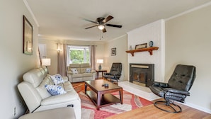 A living room with a sofa, armchair, coffee table, fireplace, and ceiling fan. - Quiet Family Home w/ Yard! 9 Mi to Dtwn Greenville (Greenville)