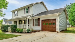 A two-story house with a front porch, a garage, and a satellite dish. - Quiet Family Home w/ Yard! 9 Mi to Dtwn Greenville (Greenville)