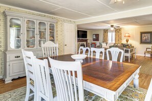 A dining room with a wooden table, white chairs, a white cabinet with glass doors, a fireplace, and a television. - 2 Mi to Cherokee Landing! Secluded Forest Escape (Higden)