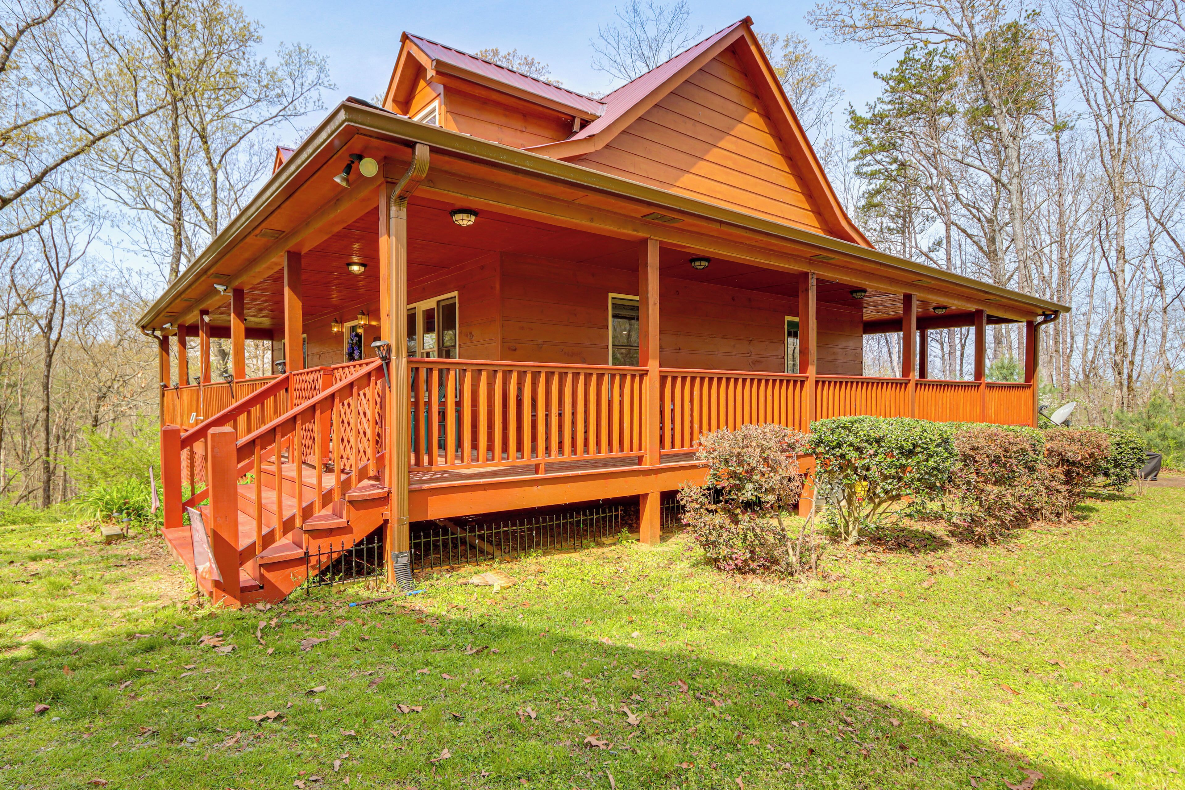 Eine Holzhütte mit Veranda, Treppe und umzäunter Garten.