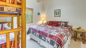 A bedroom with a bed, a wooden headboard, a nightstand, a lamp, and a framed picture on the wall. - On 4 Acres! Retreat w/ Lake Access in Maple City (Maple City)