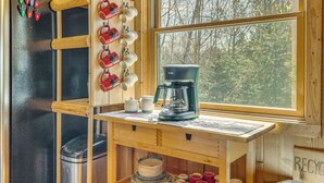 A kitchen with a coffee maker, a kettle, and a mug rack. - On 4 Acres! Retreat w/ Lake Access in Maple City (Maple City)