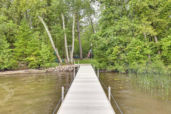 A wooden dock extending into a calm river surrounded by dense green trees. - On 4 Acres! Retreat w/ Lake Access in Maple City (Maple City)