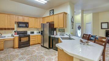 A kitchen with wooden cabinets, a stainless steel refrigerator, a microwave, and a dishwasher.